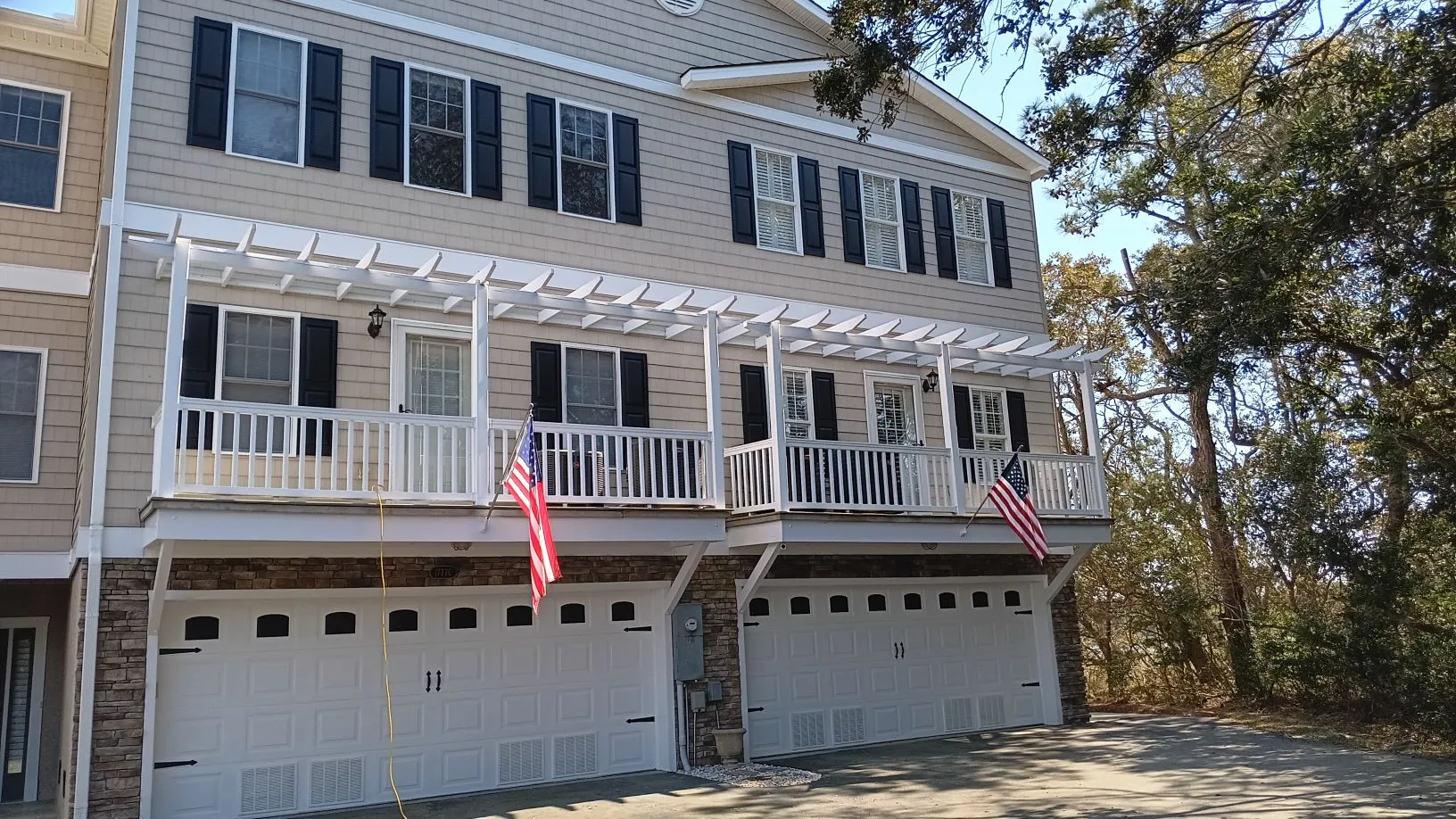 Professional installation of decorative shutters on coastal home in Caswell Beach, NC